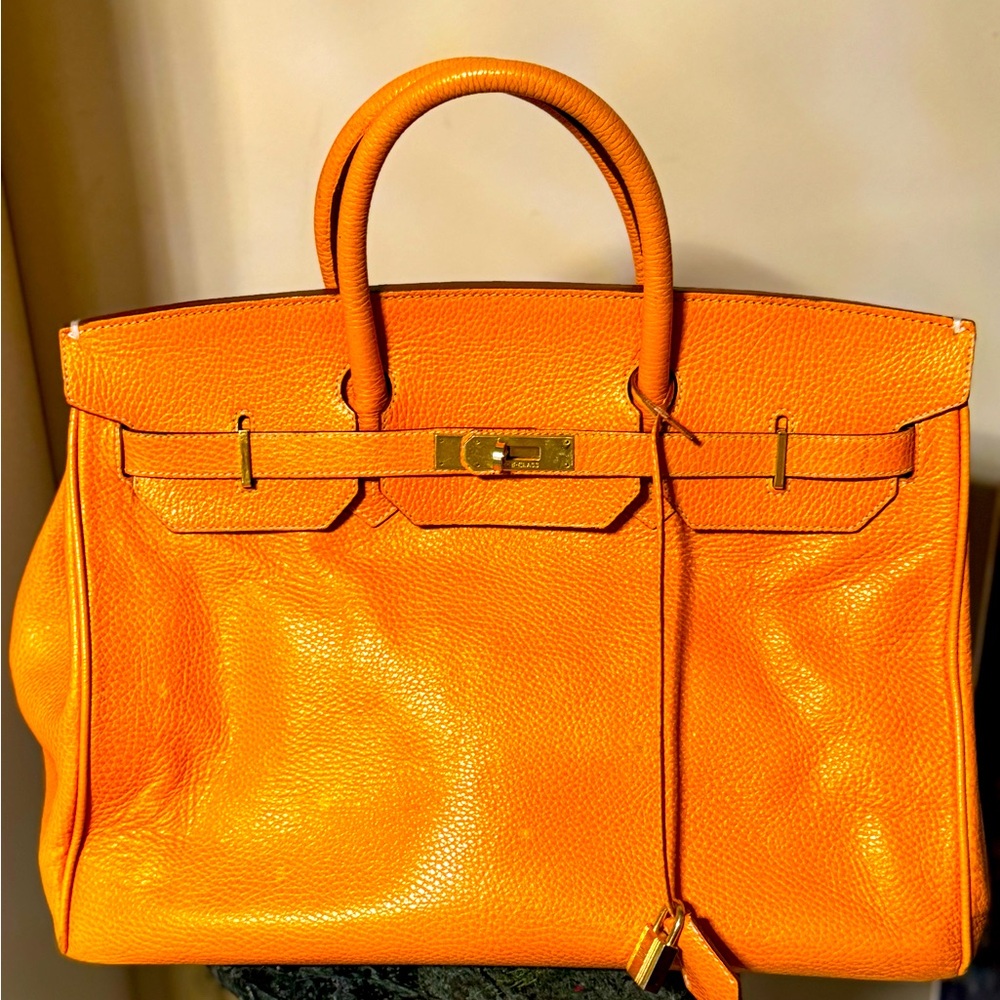 Leather orange bag with gold hardware.
